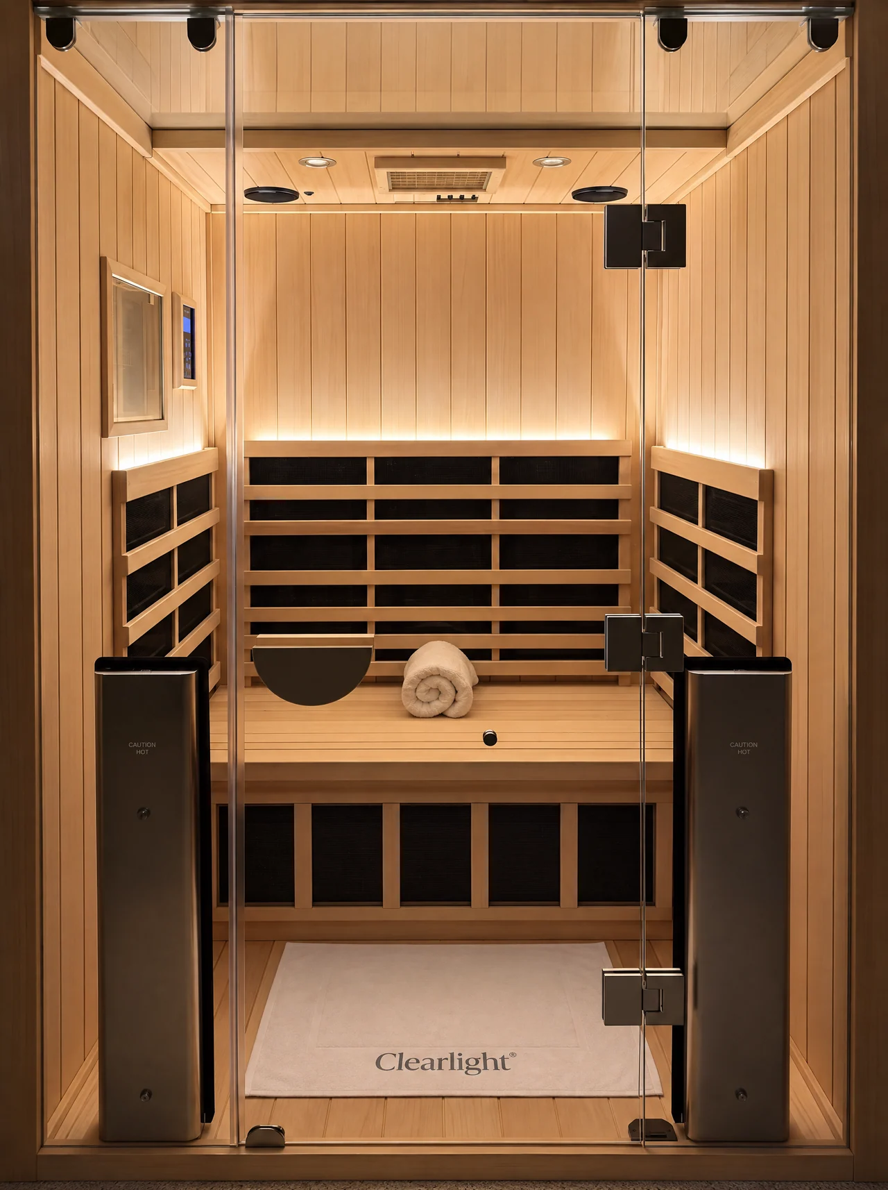 L’intérieur du sauna avec son banc en bois et sa porte vitrée